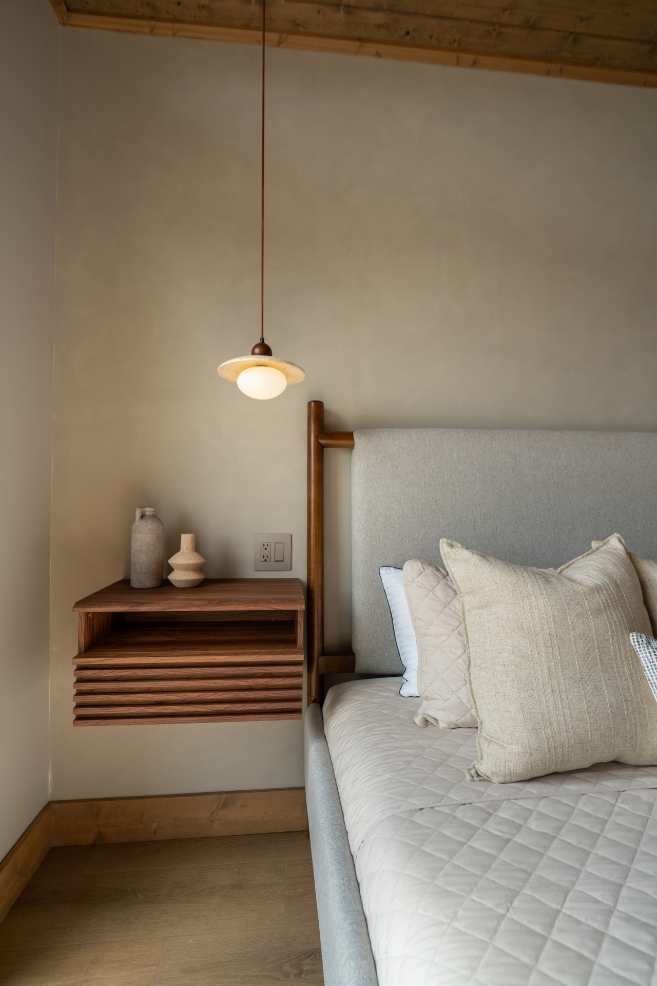 Bedroom detail with floating walnut nightstand and pendant light